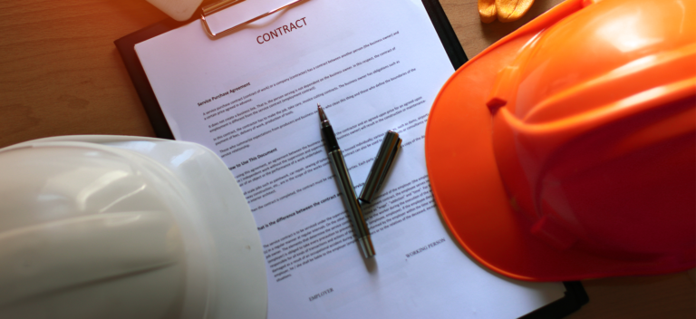 Two hard hats sitting beside a contract.