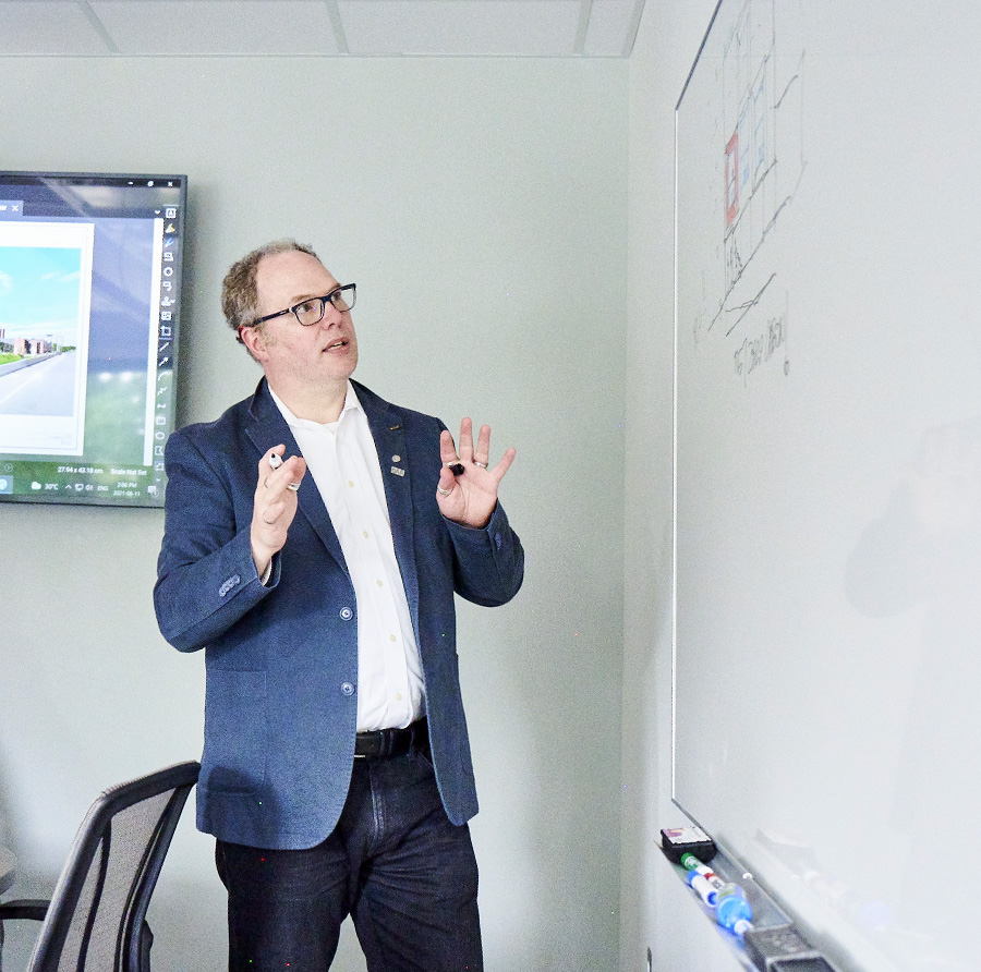 Toon reviewing a design at the white board.