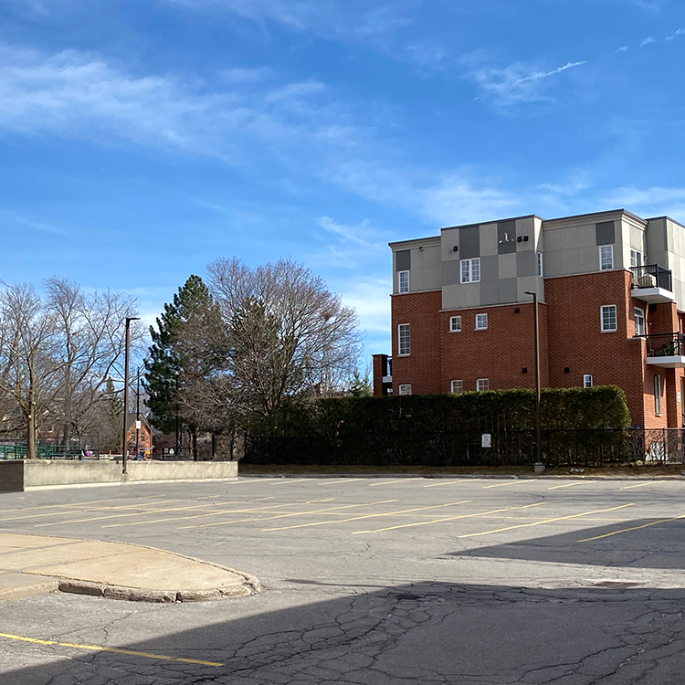 Image of a parking lot and apartment building.